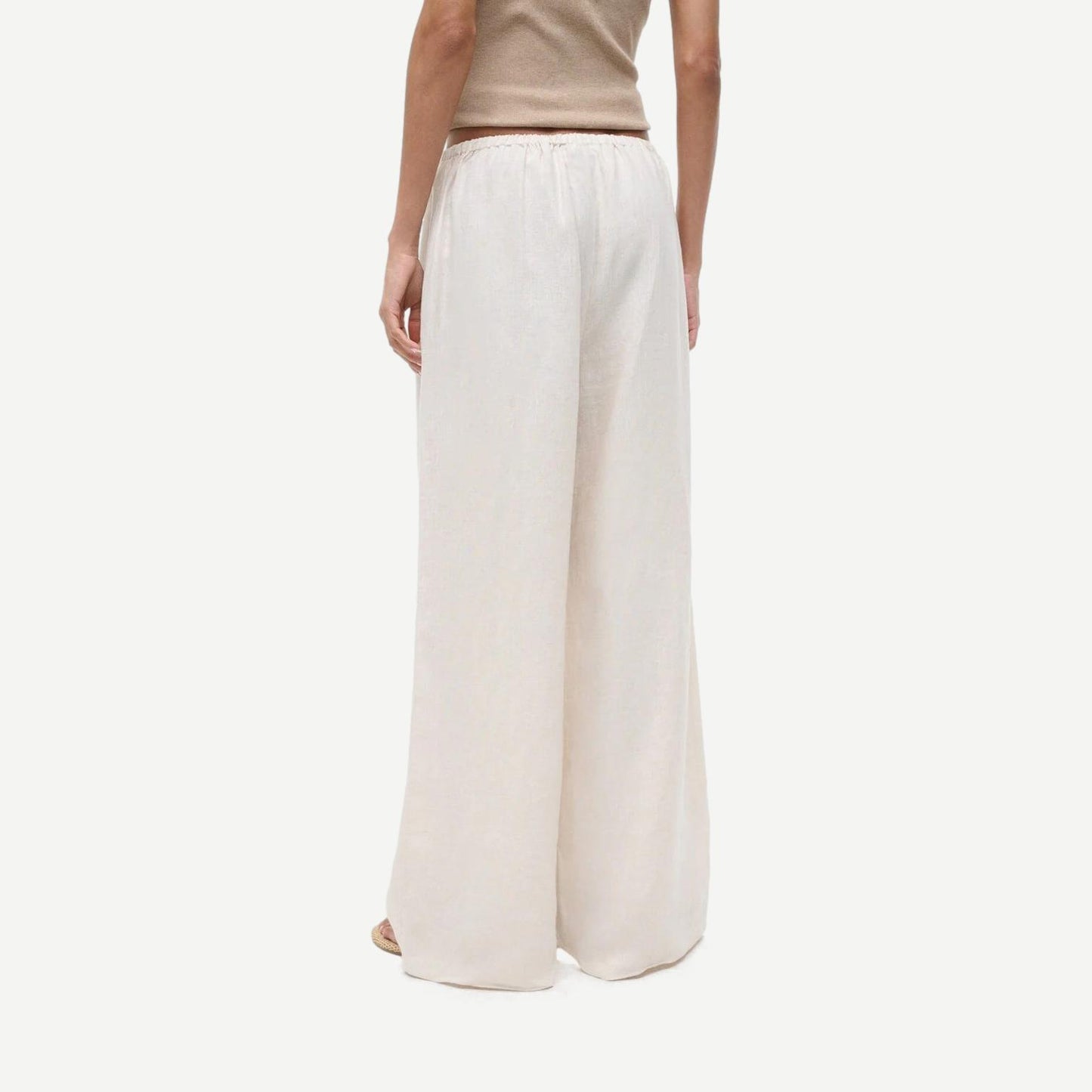 Staud Mateo Linen Pant in natural color, showing relaxed fit and lightweight fabric with subtle leg stain detail.