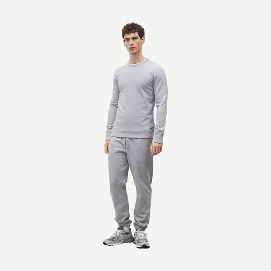 Reigning Champ men's midweight terry slim crewneck sweatshirt in heather grey, showing a close-up of the soft fabric and fit.