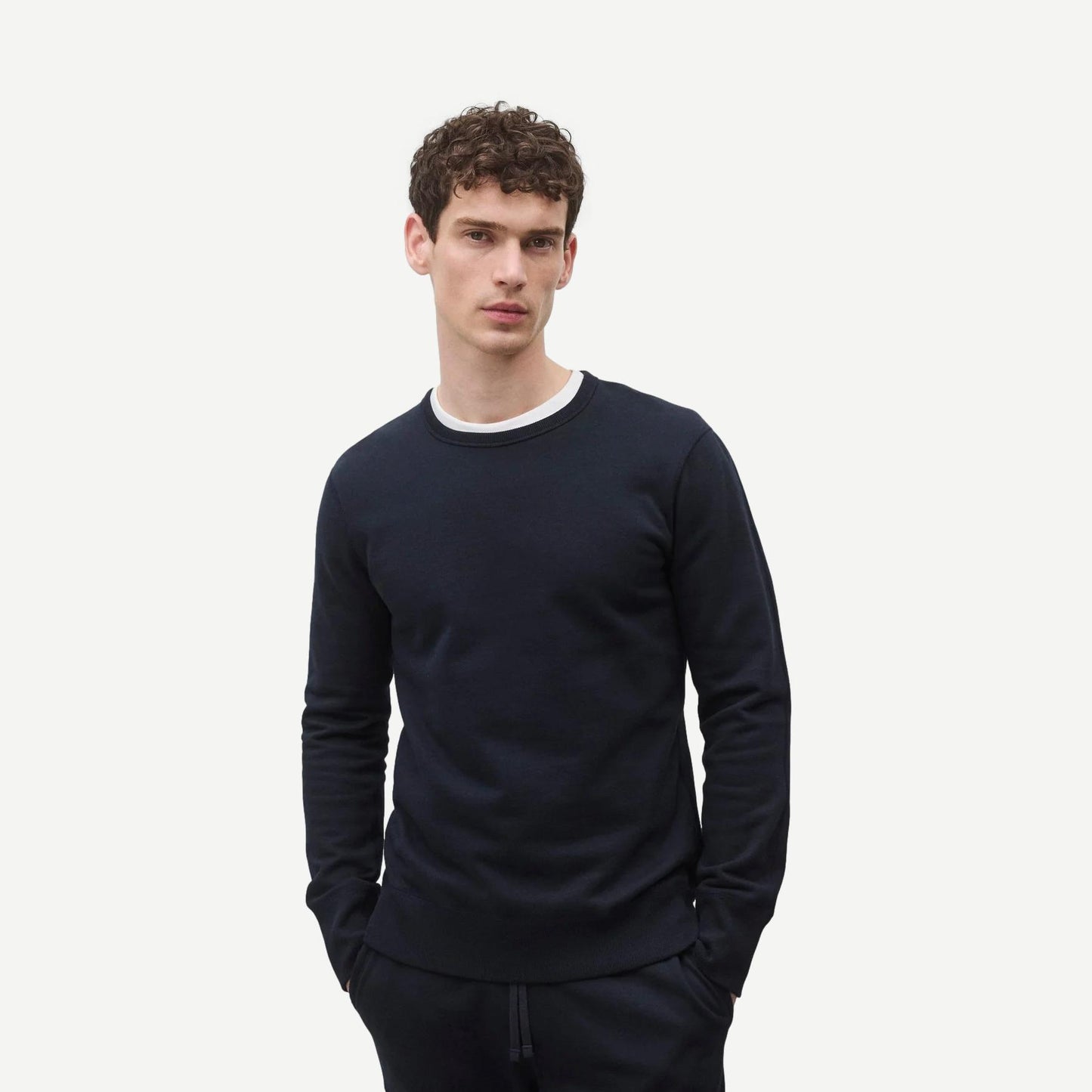 Reigning Champ navy midweight terry slim crewneck sweatshirt laid flat showing front view and soft fabric texture.