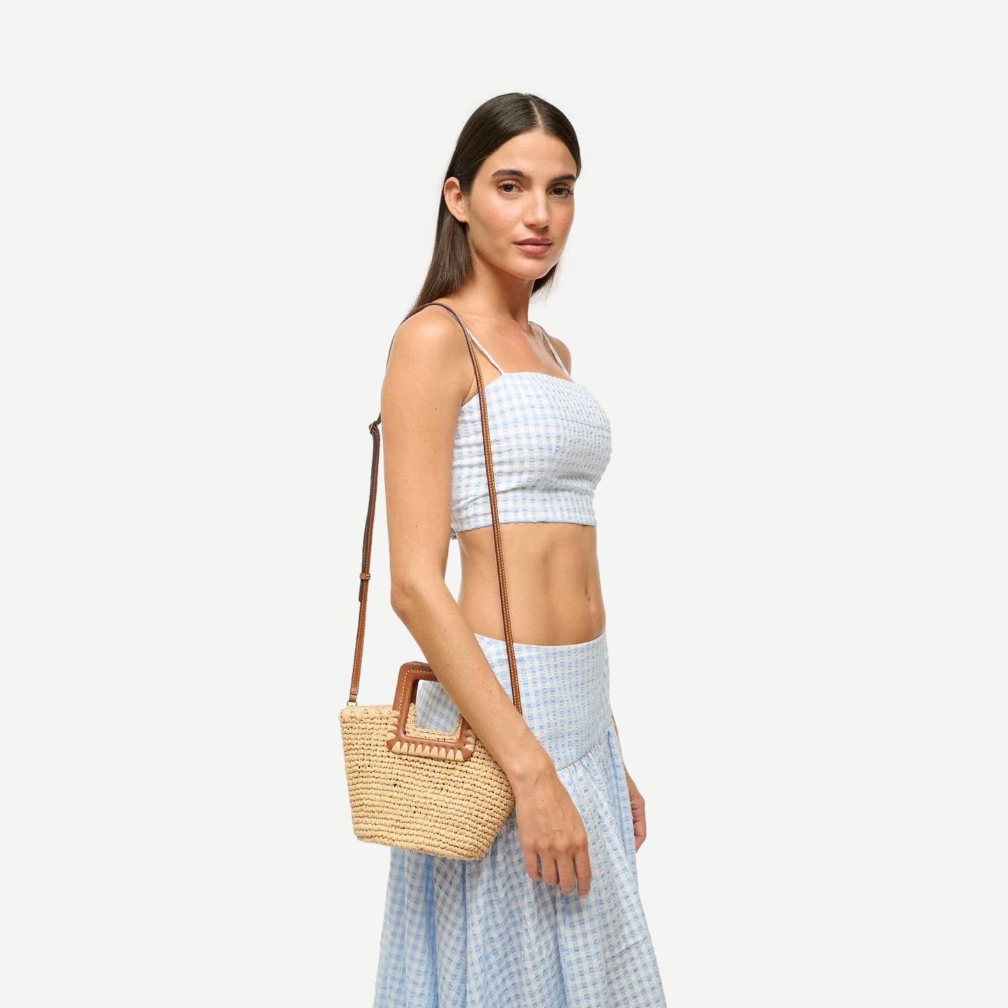 Staud Shirley Raffia Mini Bucket purse in natural and tan with woven raffia texture and small rounded shape.