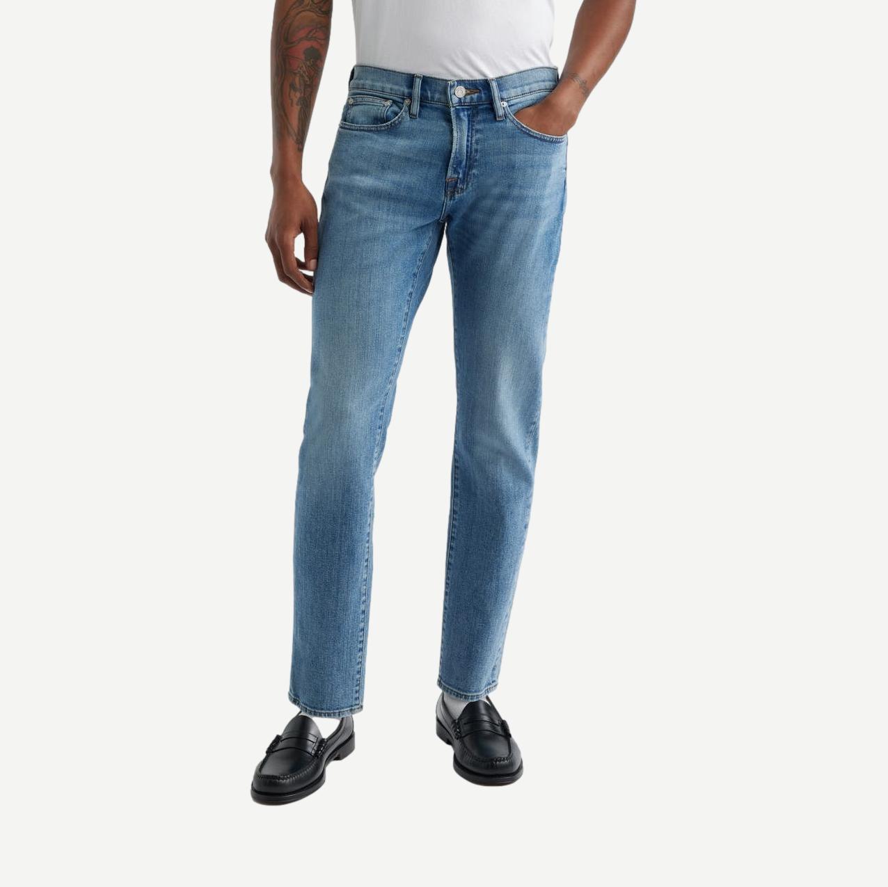 Dark blue Frame Denim L'Homme Slim Jean with classic five-pocket design and subtle fading, shown on a neutral background.