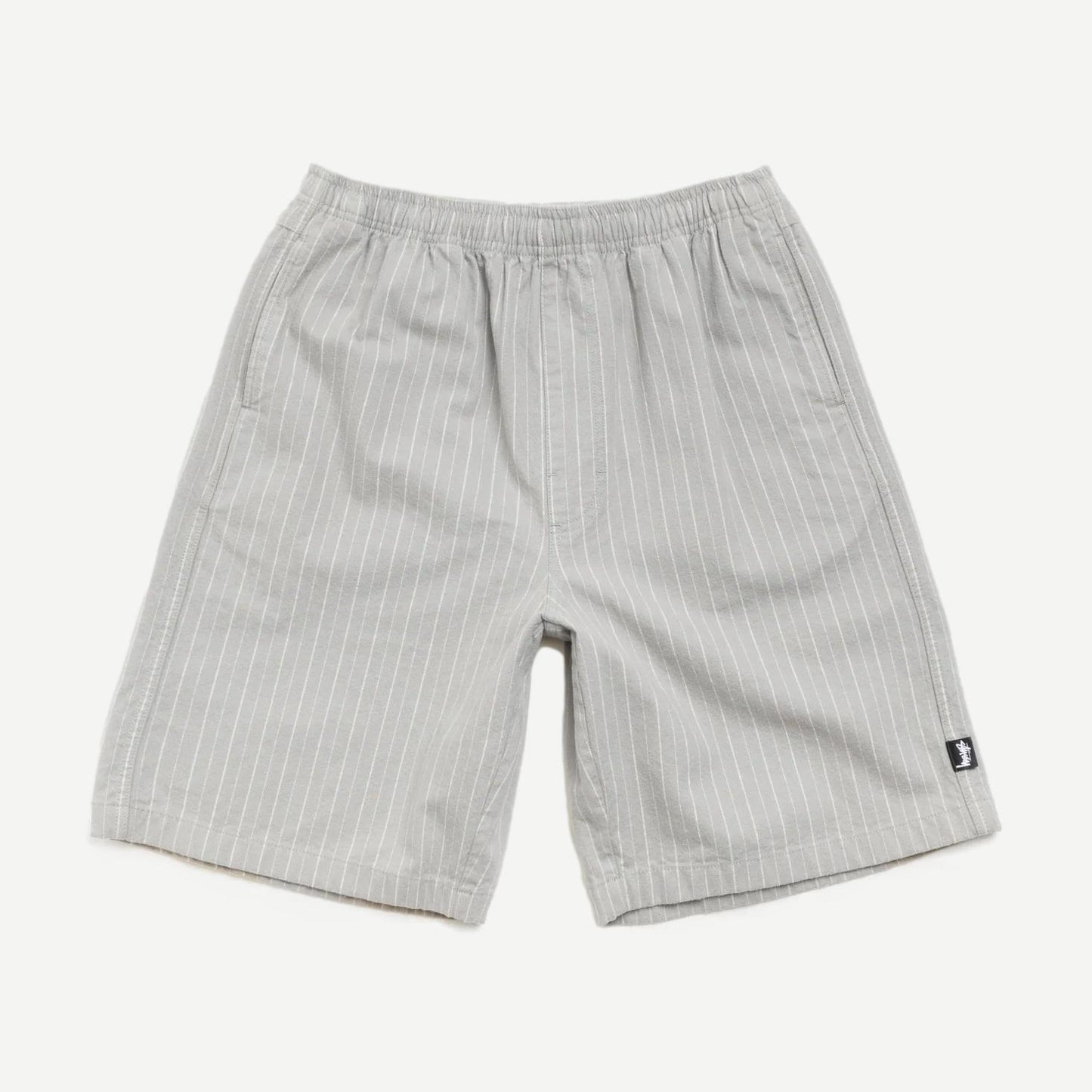 Stussy Baggy Beach Shorts in grey, loose fit with elastic waistband, casual summer shorts displayed on a model.
