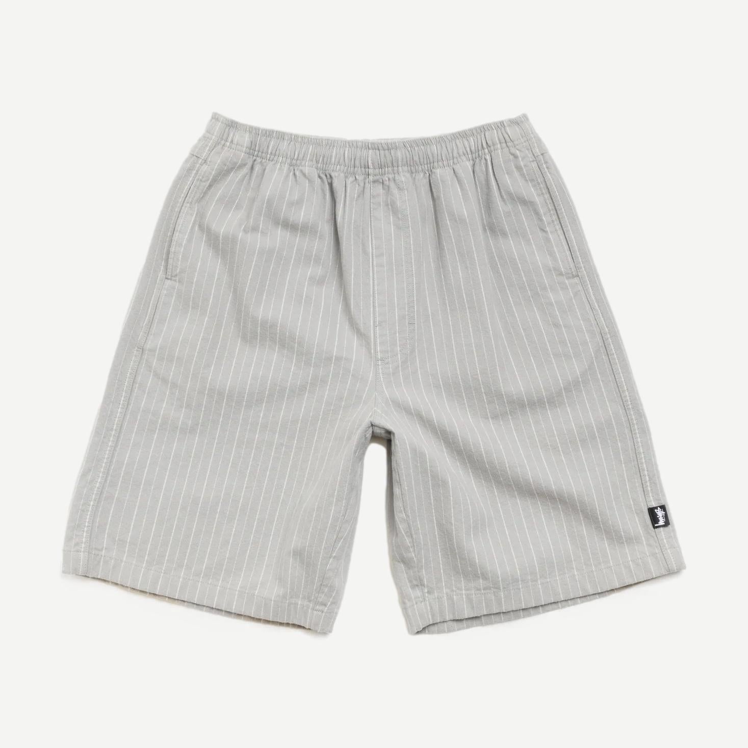Stussy Baggy Beach Shorts in grey, loose fit with elastic waistband, casual summer shorts displayed on a model.