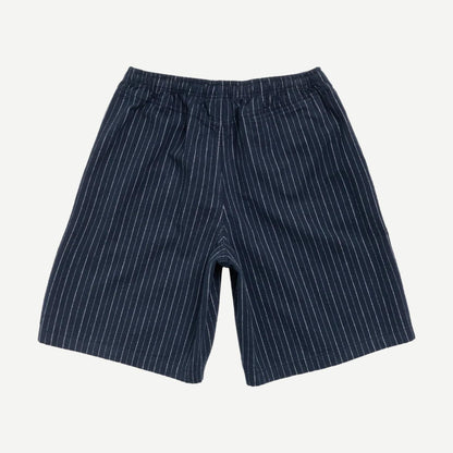 Stussy baggy navy beach shorts with relaxed fit, elastic waistband, and side pockets, ideal for casual summer wear.