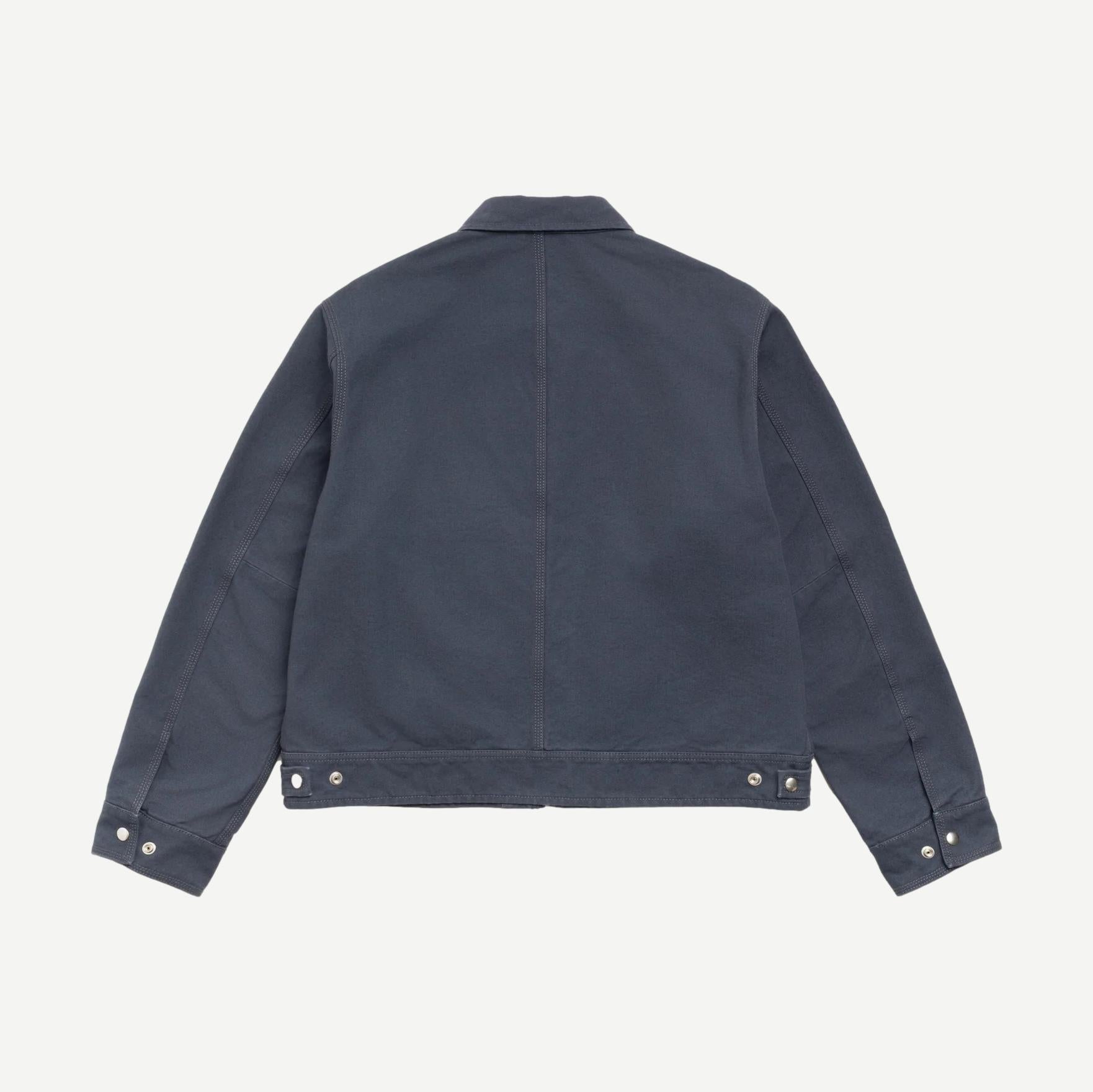 Stussy blue work jacket with collar, durable cotton fabric, front pockets, and stylish design for casual and workwear.