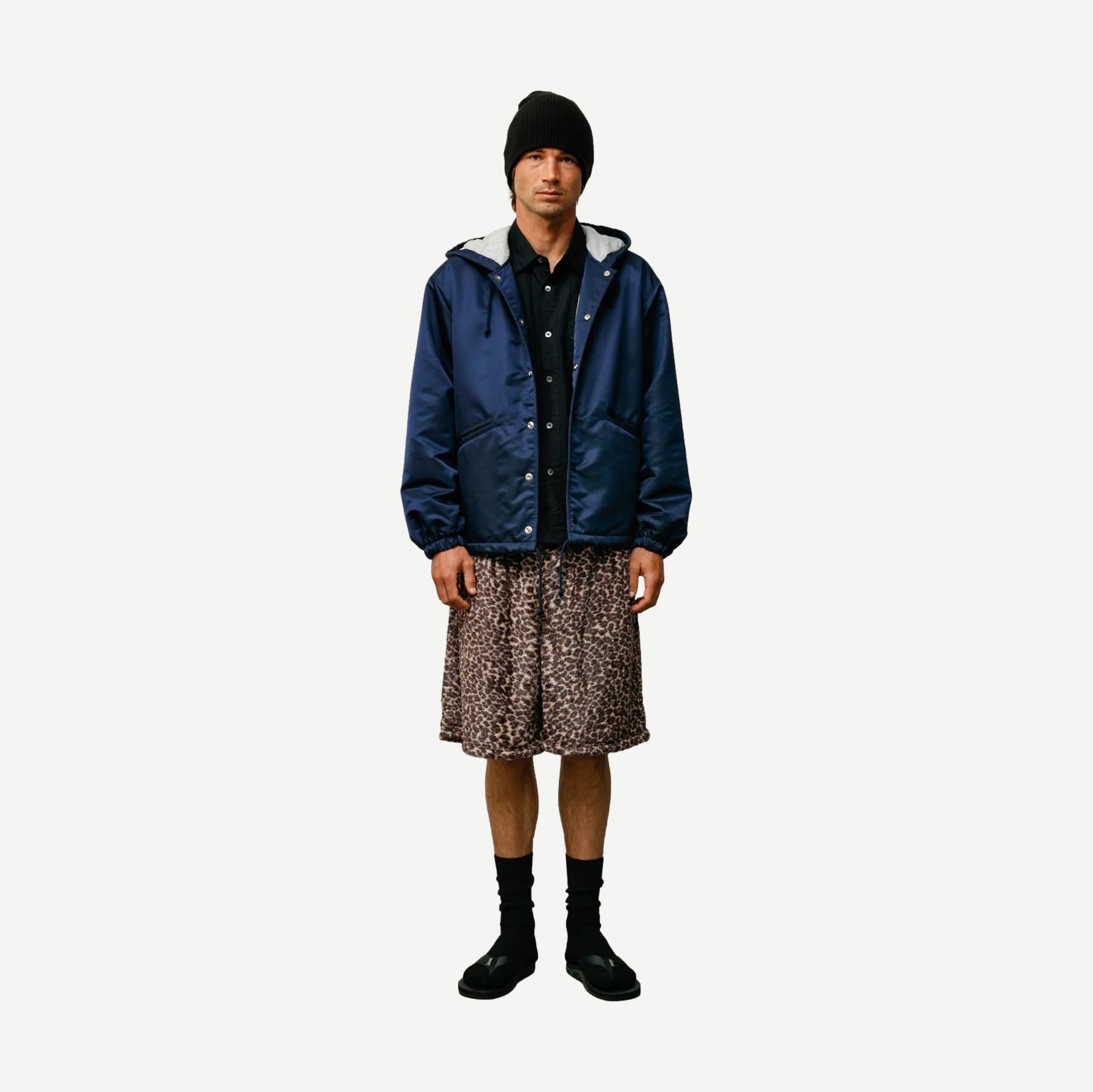 Navy hooded Stussy coaches jacket with front pockets and adjustable drawstrings, casual outerwear for streetwear style.