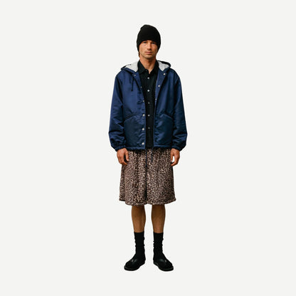 Navy hooded Stussy coaches jacket with front pockets and adjustable drawstrings, casual outerwear for streetwear style.