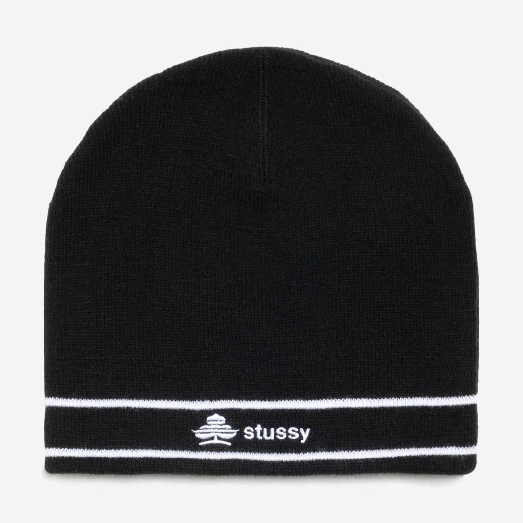 Black Stussy Clover Skullcap beanie shown on a model, featuring a snug fit and the signature Stussy logo.
