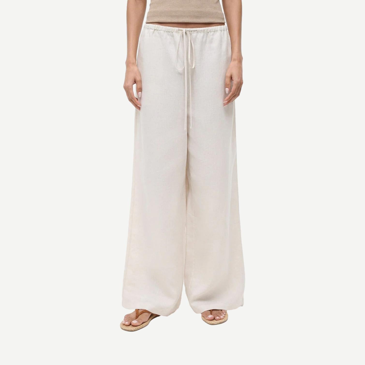 Staud Mateo linen pants in natural color, featuring a relaxed fit and lightweight fabric, displayed on a neutral background.