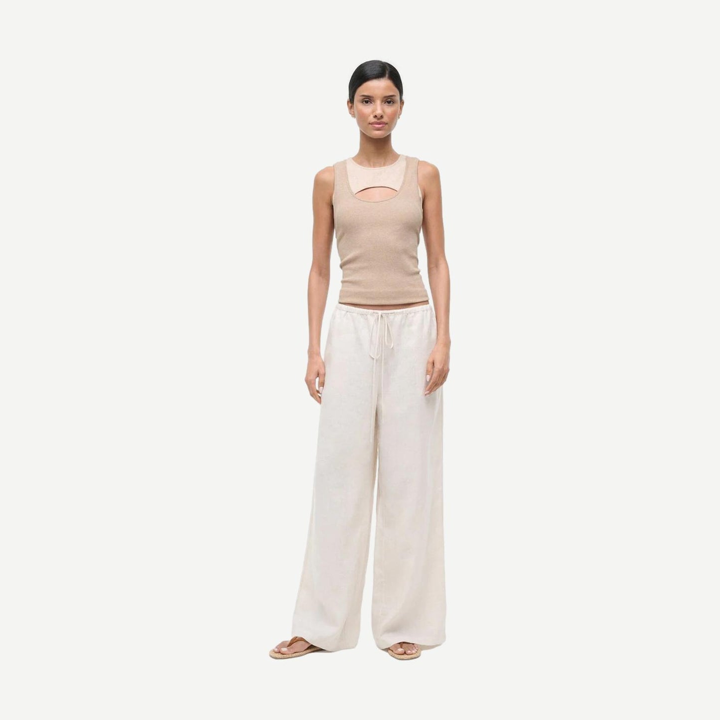 Staud Mateo Linen Pant in natural color, showing relaxed fit and lightweight fabric, with visible leg stain detail in the image.