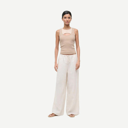 Staud Mateo Linen Pant in natural color, showing relaxed fit and lightweight fabric, with visible leg stain detail in the image.