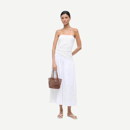 Staud Caro Bucket Bag in tan leather, stylish purse with a rounded shape and shoulder strap, on a white background.