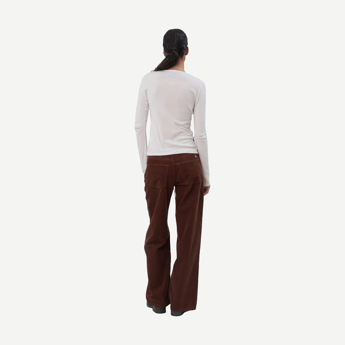 Still Here cool chocolate corduroy denim jeans, close-up of stylish chocolate-colored fabric and classic denim texture.
