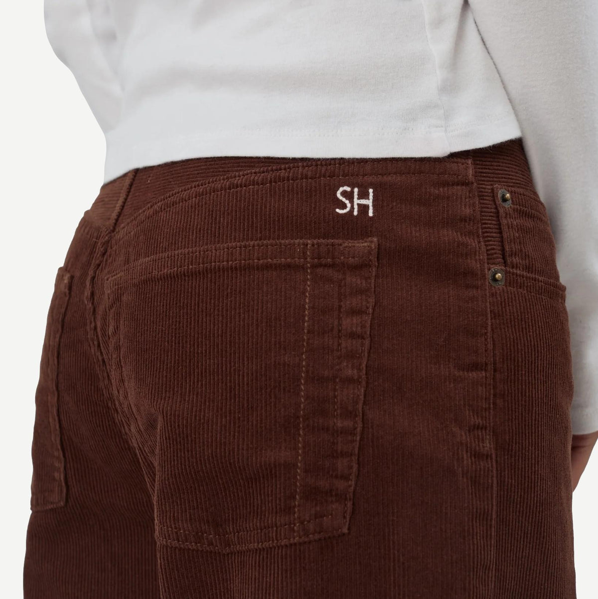 Still Here cool chocolate corduroy denim jeans, close-up of textured fabric and classic denim style in rich brown color.