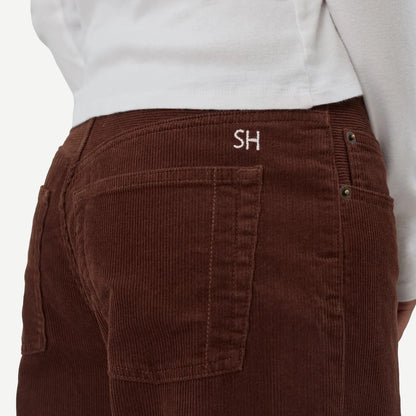 Still Here cool chocolate corduroy denim jeans, close-up of textured fabric and classic denim style in rich brown color.