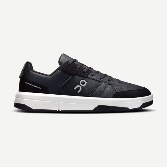 On Cloud Roger Clubhouse Men black and white footwear with sporty design and rounded toe, displayed on a plain background.