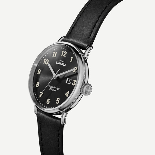 Shinola Canfield 3HD black leather watch with 38mm black dial and stainless steel case, showing the watch face and strap.