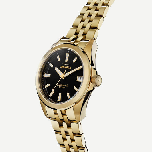 Shinola Circadian Monster automatic watch with 36mm gold and black case, featuring a sleek dial and stainless steel bracelet.