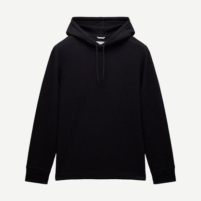 Reigning Champ black lightweight waffle hoodie sweatshirt displayed on a hanger, showcasing its soft fabric and casual style.