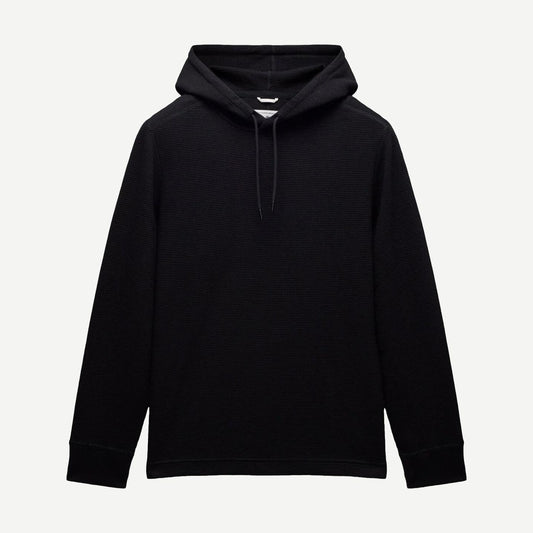 Reigning Champ black lightweight waffle hoodie sweatshirt displayed on a hanger, showcasing its soft fabric and casual style.