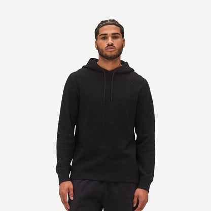 Reigning Champ black lightweight waffle hoodie sweatshirt with a relaxed fit and ribbed cuffs, displayed on a hanger.