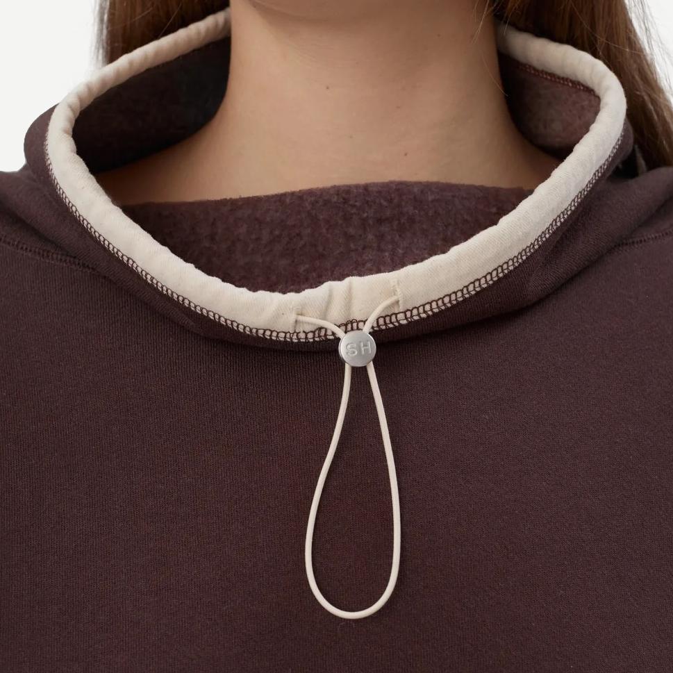 Still Here chocolate brown Rec Pullover sweatshirt, cozy fleece fabric, casual fit, displayed on a hanger.