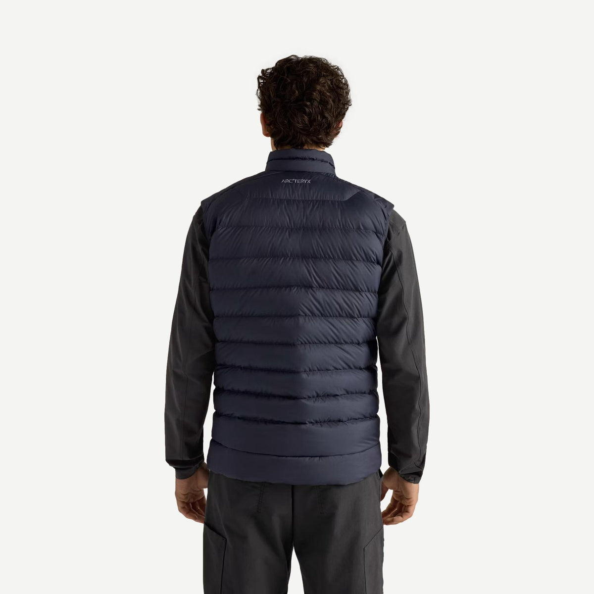 Back view of Arcteryx Cerium Vest for men in black sapphire, showcasing its sleek design and lightweight insulation.