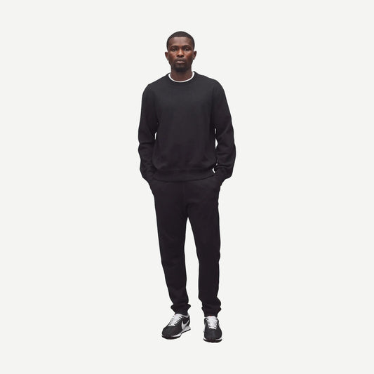 Reigning Champ black midweight terry slim sweatpants laid flat, showcasing their minimalist design and comfortable fit.