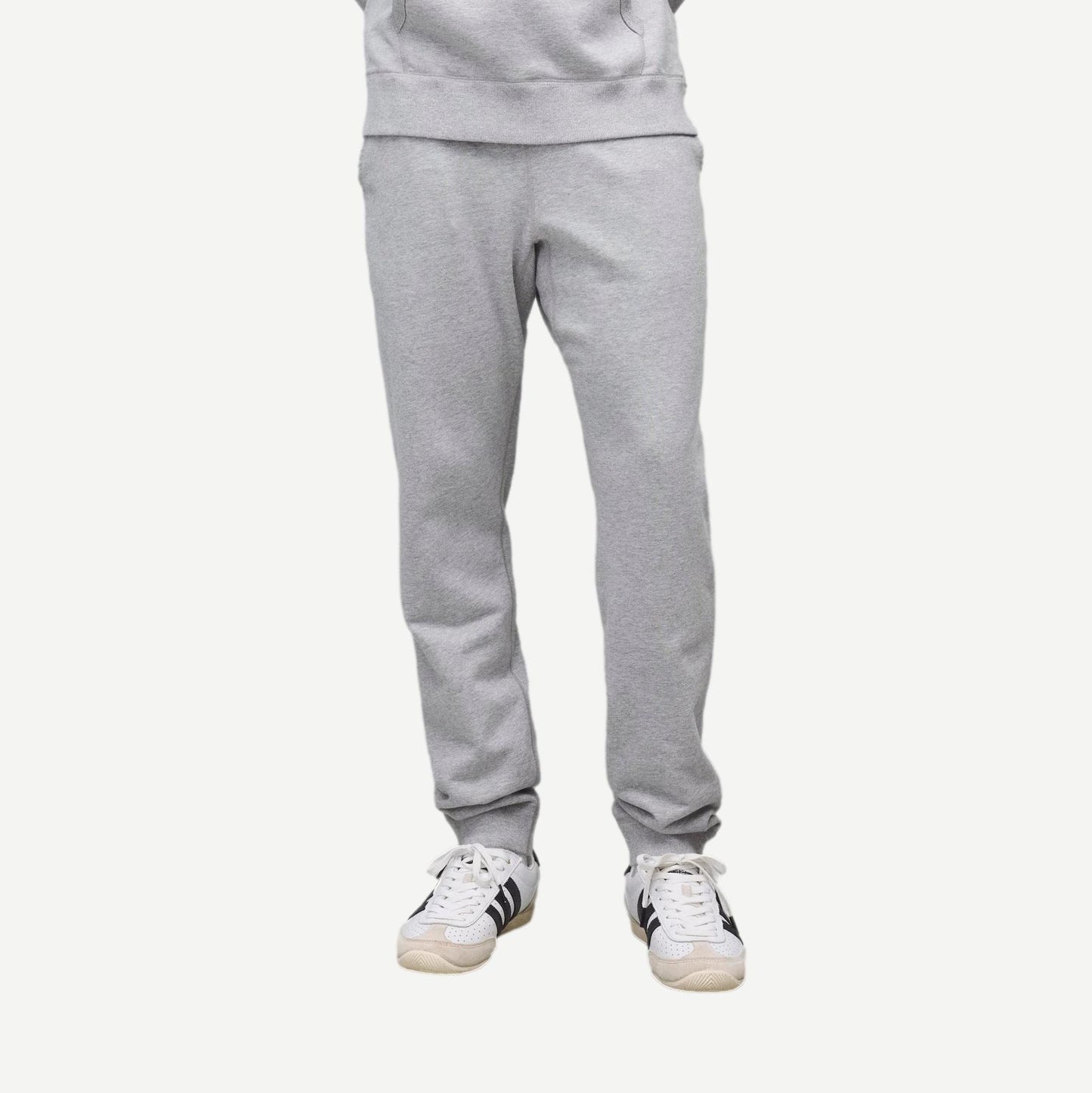 Reigning Champ Heather Grey midweight terry slim sweatpants displayed on a model, showcasing soft fabric and modern fit.