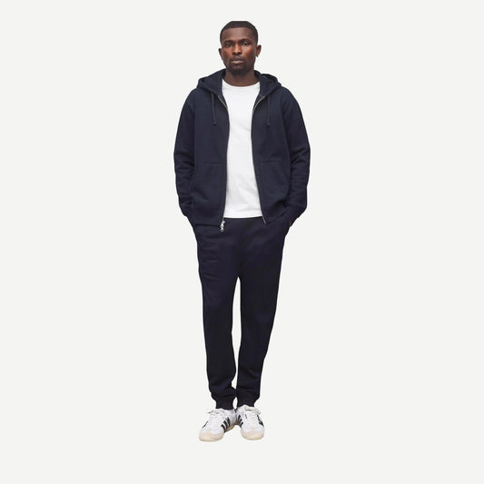 Reigning Champ navy midweight terry slim sweatpants shown on a model, featuring a relaxed fit and elastic waistband.