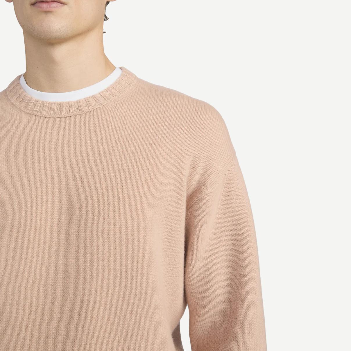 Pale peach cashmere crewneck sweater by Frame Denim, featuring a soft texture and classic silhouette.