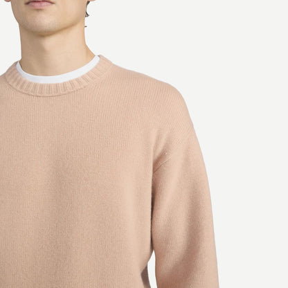 Pale peach cashmere crewneck sweater by Frame Denim, featuring a soft texture and classic silhouette.