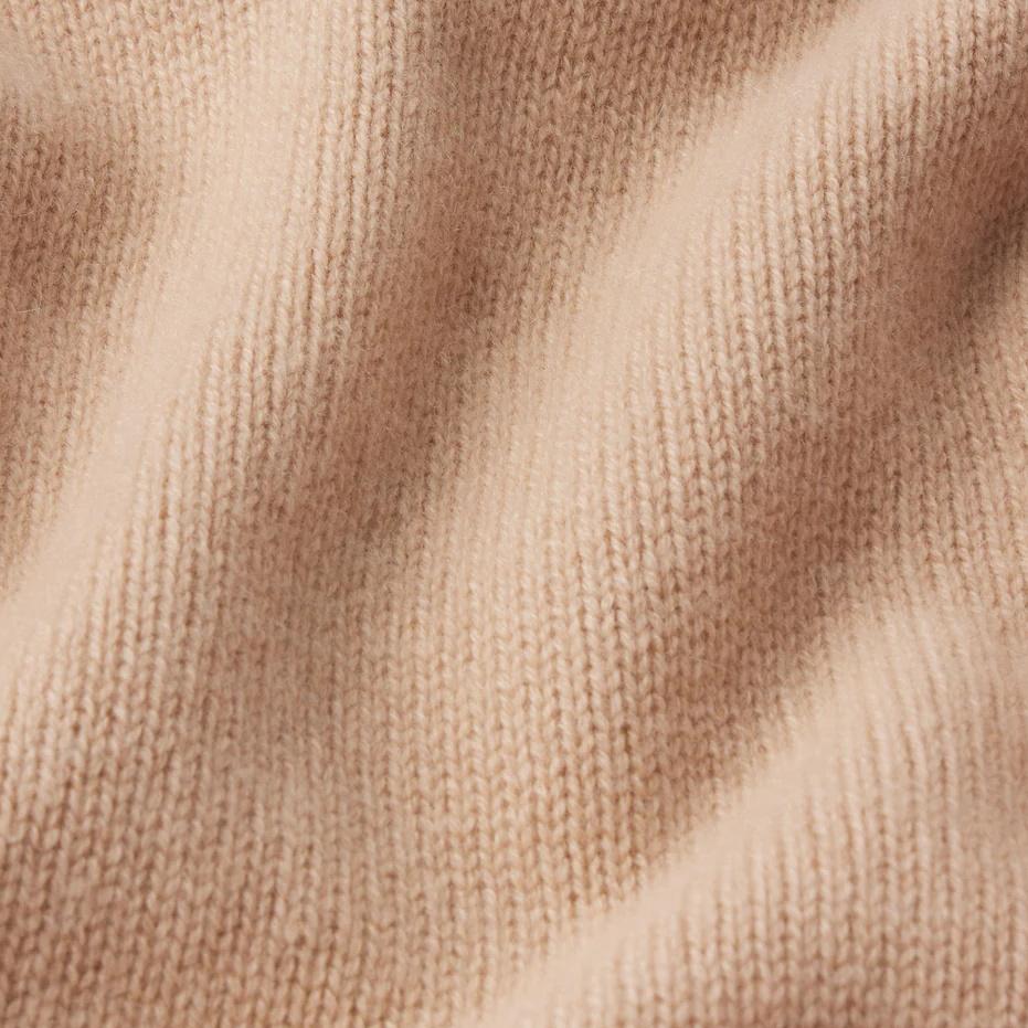 Pale peach cashmere crewneck sweater by Frame Denim, showcasing soft texture and classic design.