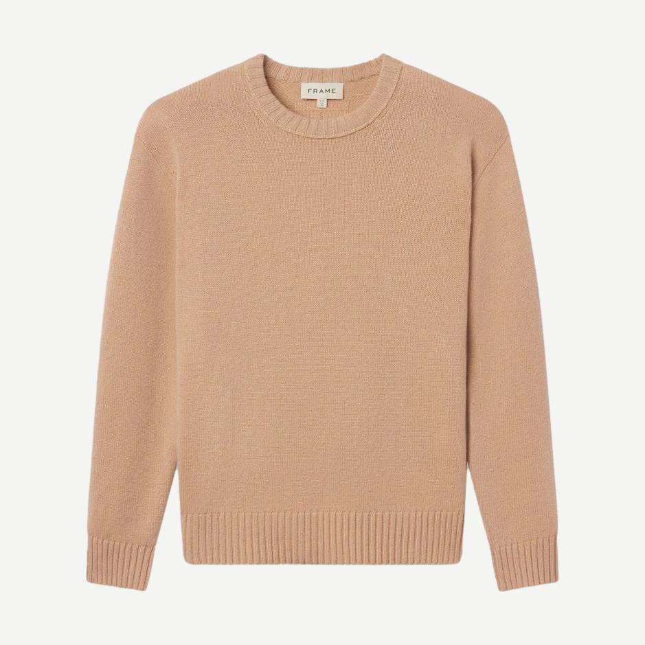Pale peach cashmere crewneck sweater by Frame Denim, featuring a classic fit and soft texture displayed on a neutral background.