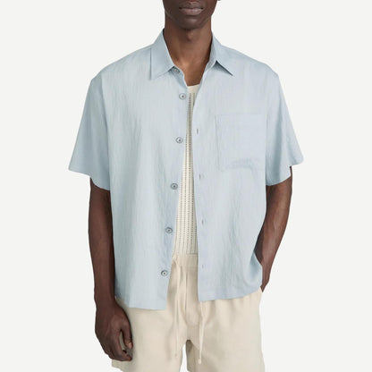 Blue grey striped lightweight short-sleeve button-up shirt by Frame Denim, styled on a hanger.