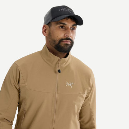 Black and cloud-colored Arcteryx Bird Word Trucker Hat featuring mesh panels and adjustable strap for a casual outdoor look.