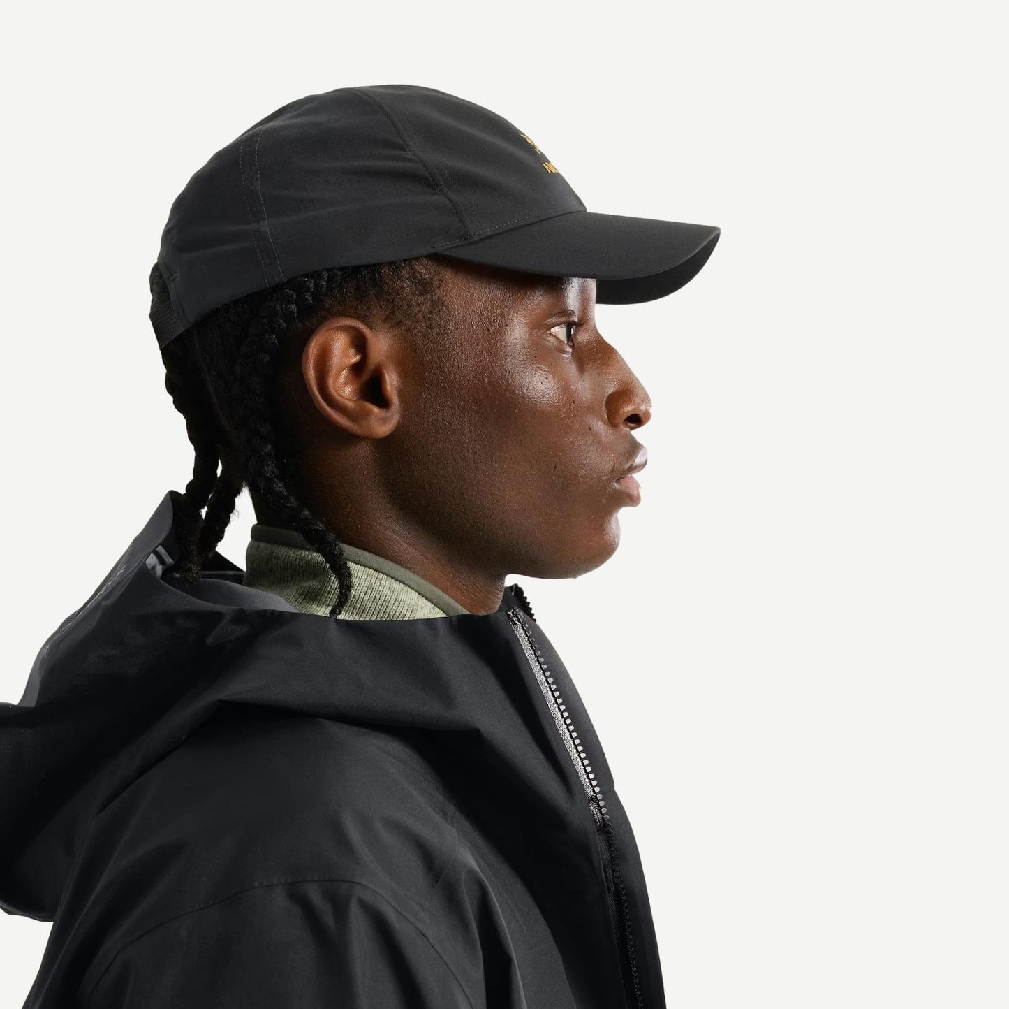 Black Bird Word Cap by Arc’teryx, a stylish black hat featuring the brand logo, shown from a side view.