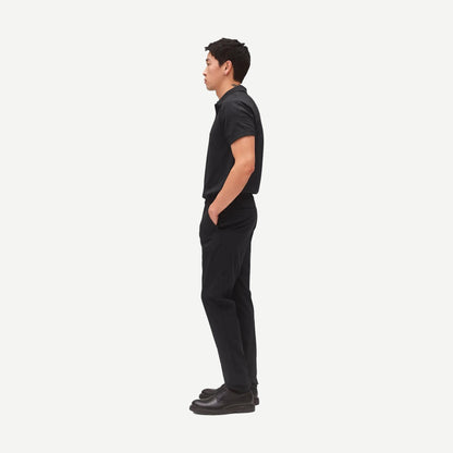 Reigning Champ black stretch warp knit coach's slim pants displayed on a model, featuring a sleek fit and modern design.