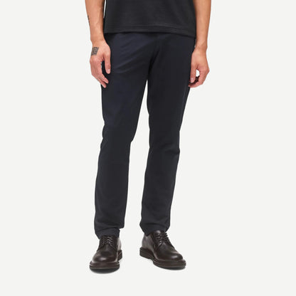 Reigning Champ navy Stretch Warp Knit Coach's Slim Pants displayed on a model, highlighting slim fit and smooth fabric texture.