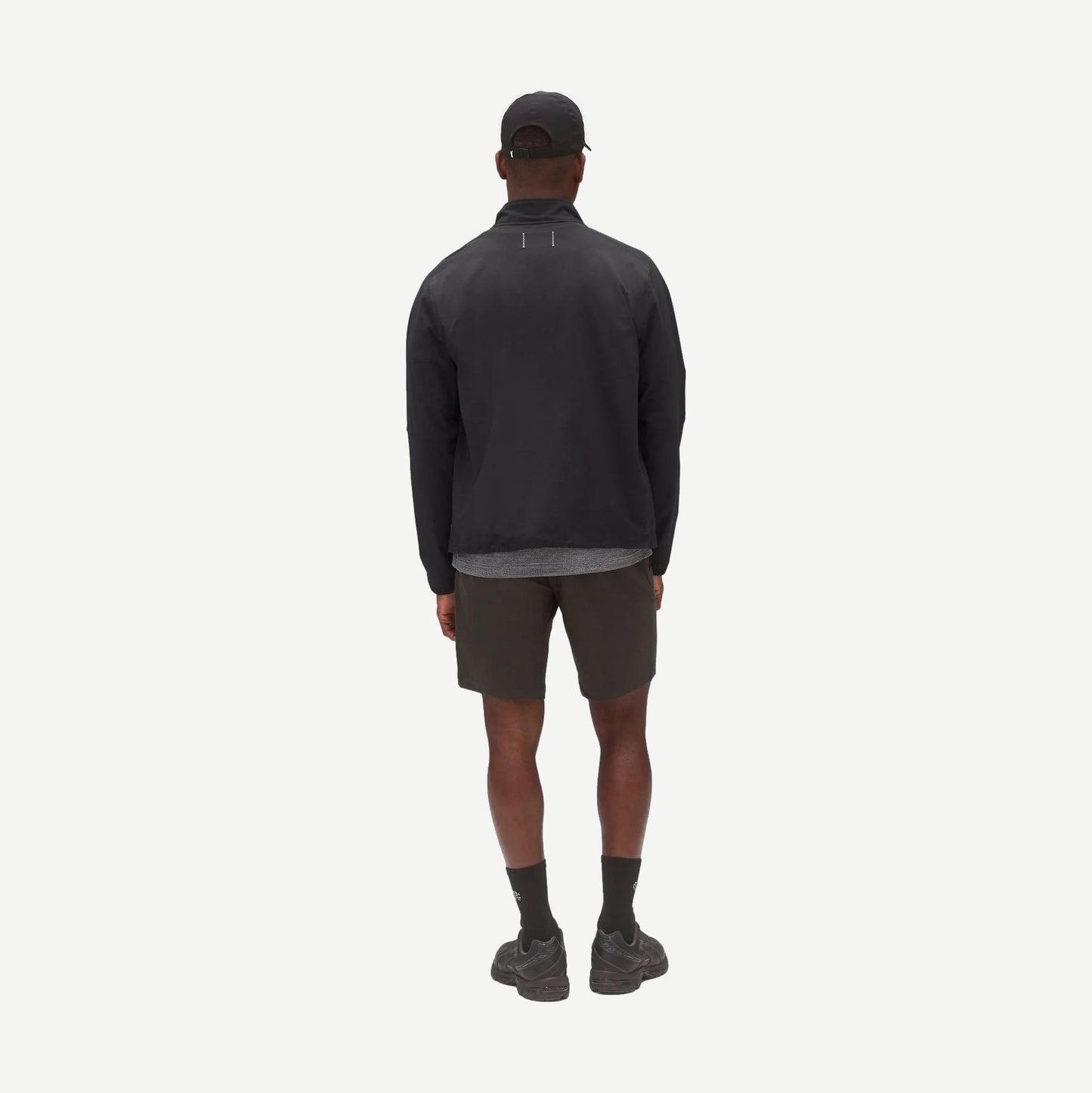 Reigning Champ Stretch Warp Knit Coach's Slim Shorts 9-inch in carbon color, shown on a model with a relaxed fit.