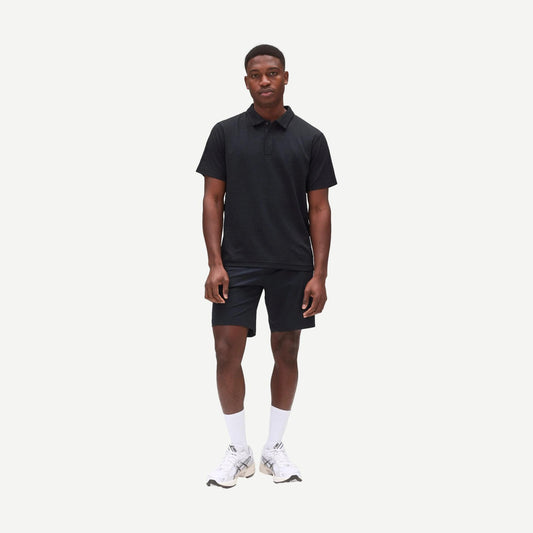 Reigning Champ navy Stretch Warp Knit Coach's Slim Shorts, 9-inch length, displayed on a hanger.