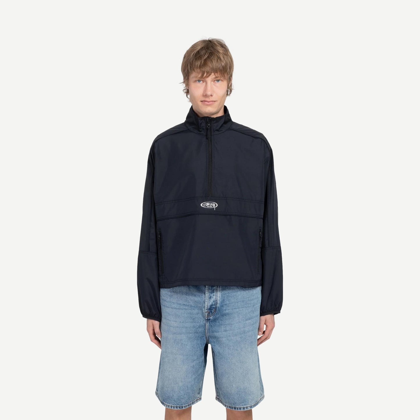 Black lightweight pullover jacket by Stussy, shown on a model with a relaxed fit and subtle branding details.