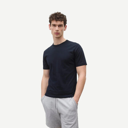 Reigning Champ navy lightweight jersey slim T-shirt displayed on a hanger with a close-up of fabric texture.