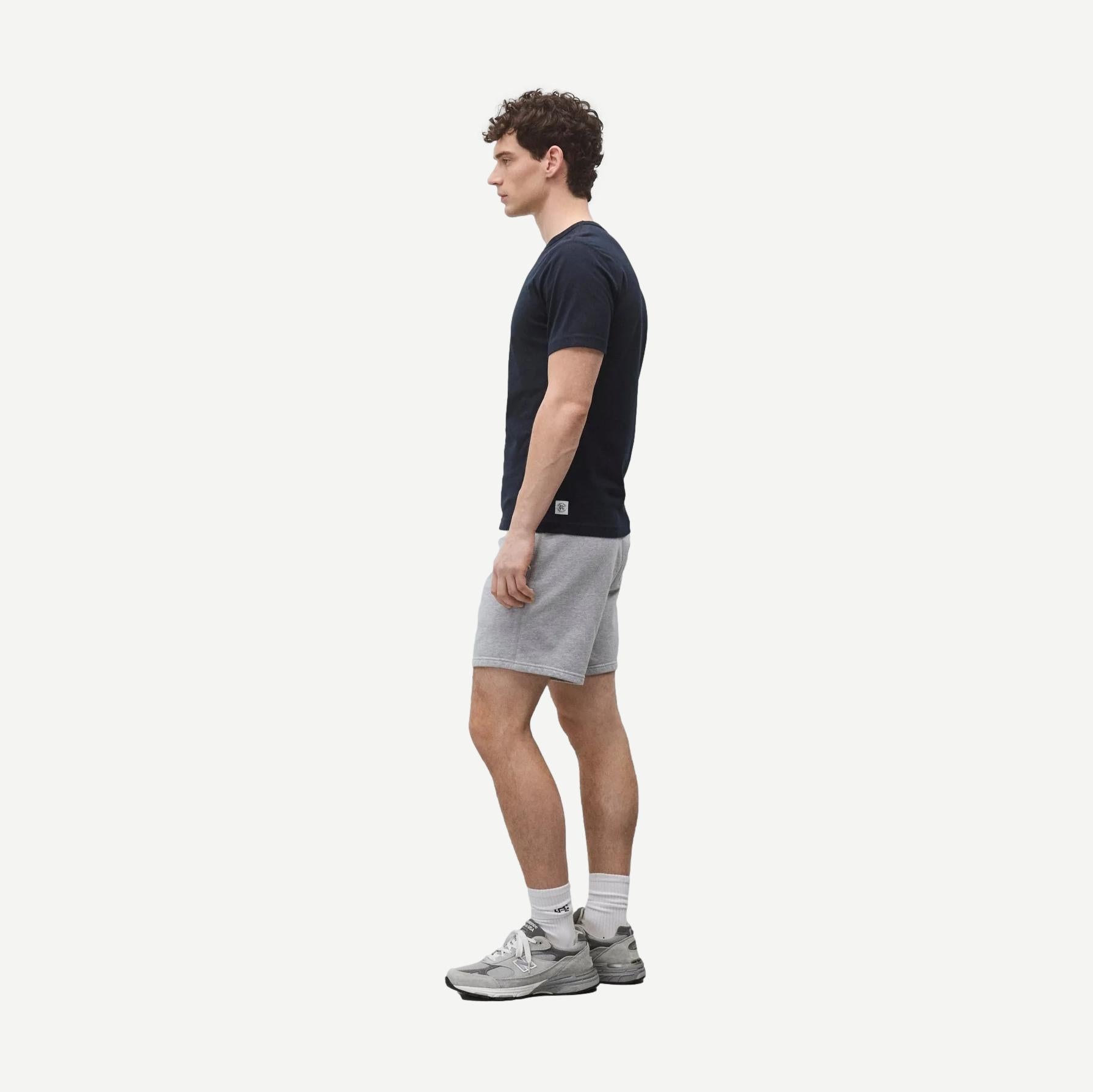 Navy lightweight jersey slim T-shirt by Reigning Champ displayed on a hanger. Comfortable fit, soft fabric, and classic design.