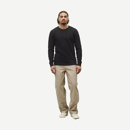 Black lightweight waffle Henley shirt by Reigning Champ, featuring a classic standard fit and textured fabric, displayed on a hanger.