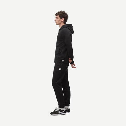 Black Reigning Champ midweight terry slim zip hoodie with front pockets and a stand-up collar, displayed on a hanger.