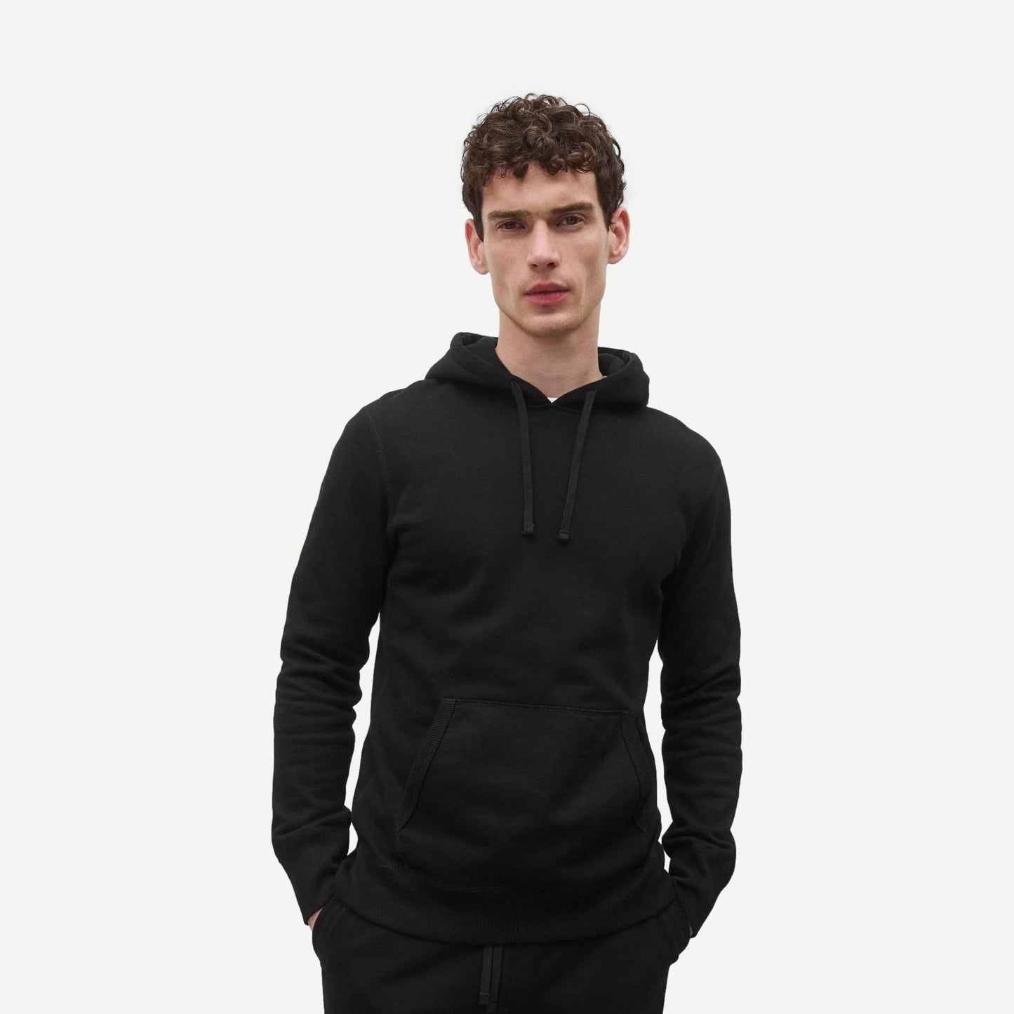 Reigning Champ black midweight terry slim hoodie sweatshirt, showing front view with hood and relaxed fit.