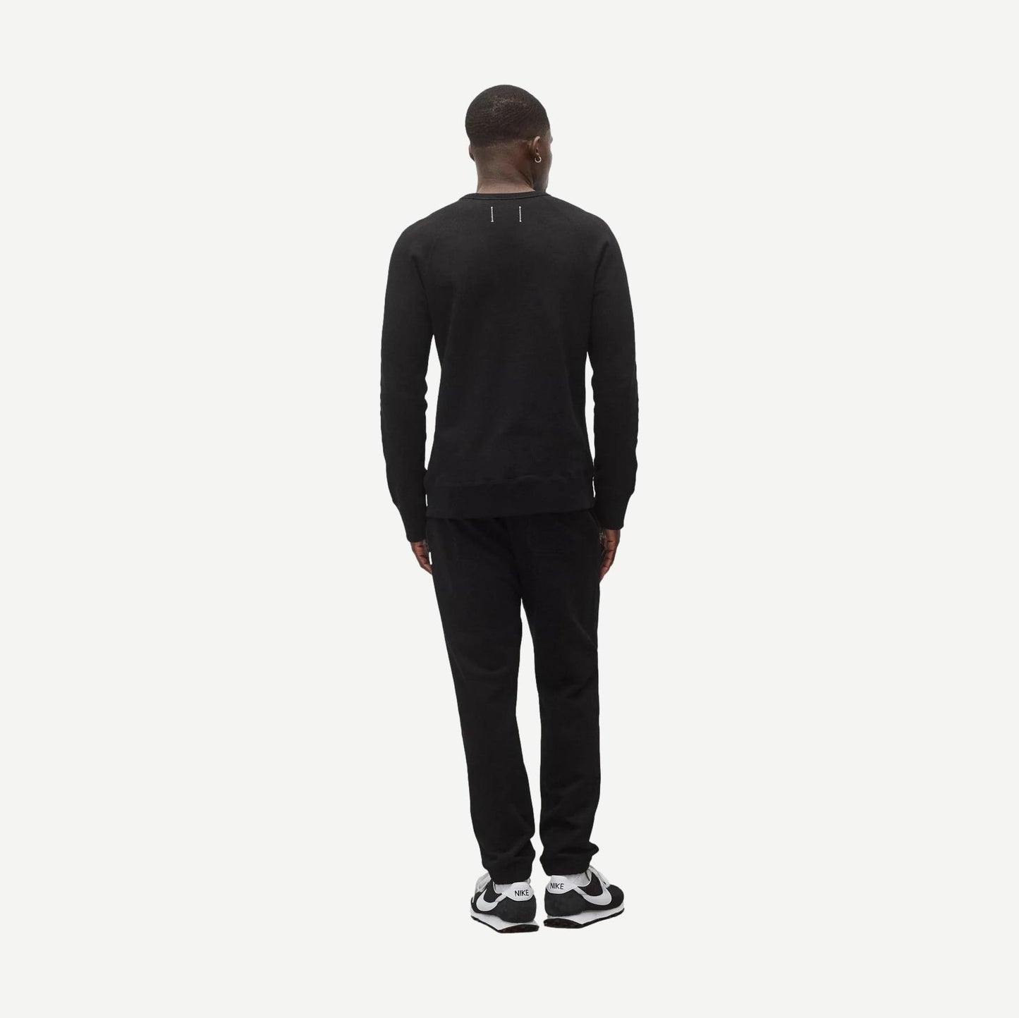 Reigning Champ black midweight terry slim crewneck sweatshirt displayed on a model, showcasing a classic fit and soft fabric.
