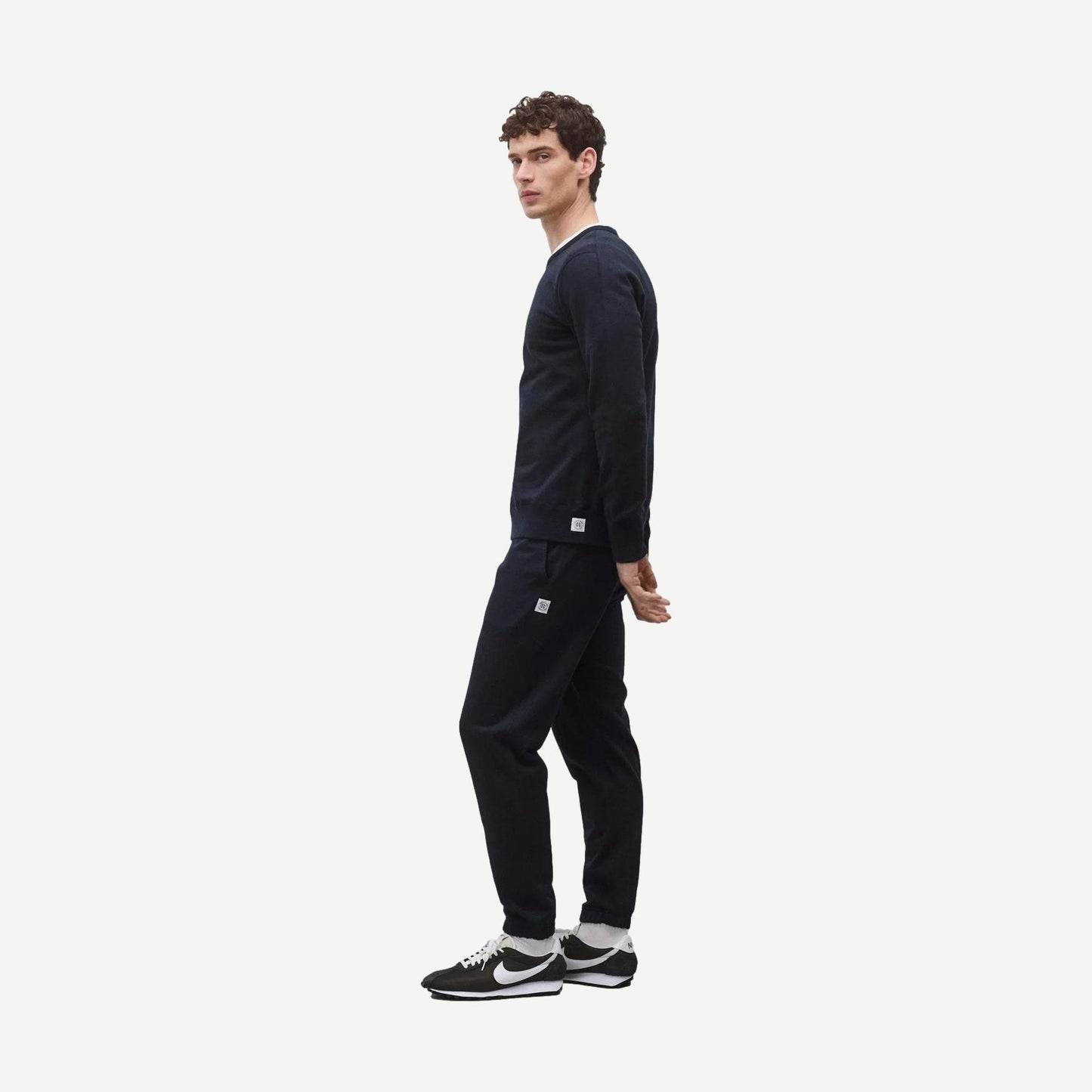 Reigning Champ navy midweight terry slim crewneck sweatshirt displayed on a hanger against a plain background.