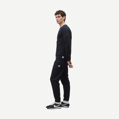 Reigning Champ navy midweight terry slim crewneck sweatshirt displayed on a hanger against a plain background.